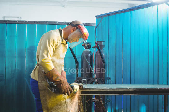 Schweißer arbeitet in Werkstatt an Metallstück — Stockfoto