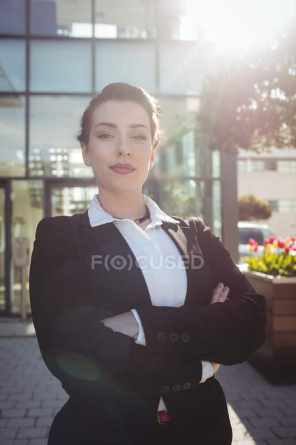 Портрет молодої бізнес-леді зі зброєю, що стоїть у сонячний день — стокове фото
