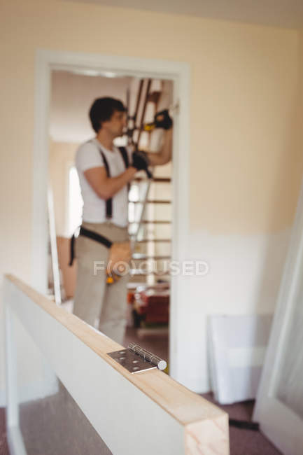 Красивый плотник, работающий над дверной рамой дома — стоковое фото