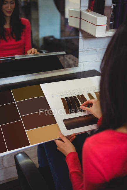 Woman selecting hair color at hair salon — Stock Photo