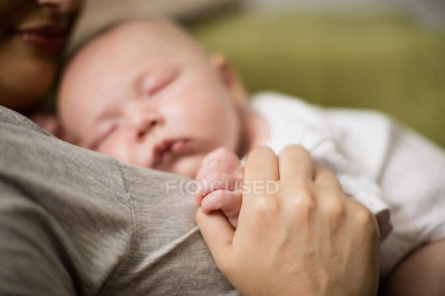 Selective focus of baby sleeping on mother in living room at home — Stock Photo