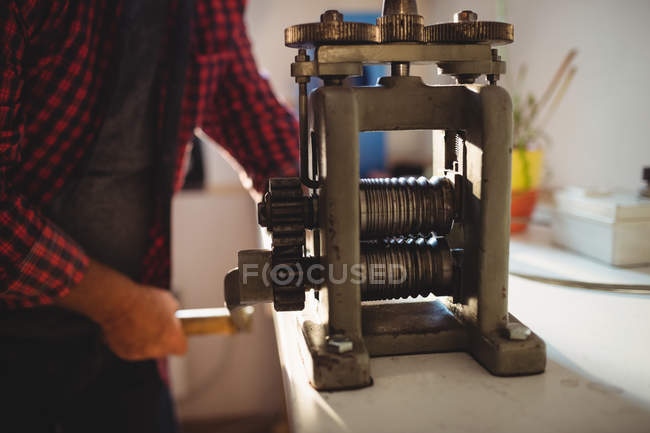 Mid section of goldsmith manufacturing ring in workshop — Stock Photo