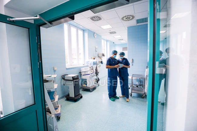 Cirujanos discutiendo sobre tableta digital en un hospital - foto de stock