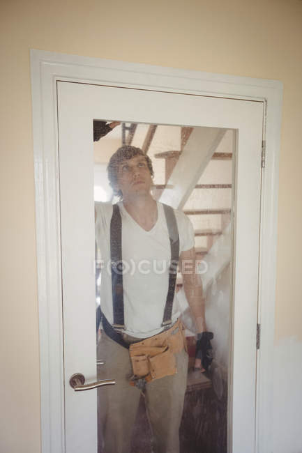 Hermoso carpintero fijación puerta en casa - foto de stock