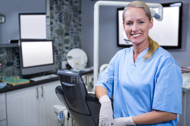 Assistant dentaire souriant à la caméra à la clinique dentaire — Photo de stock