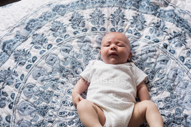 Baby lying on bed in bedroom at home — Stock Photo