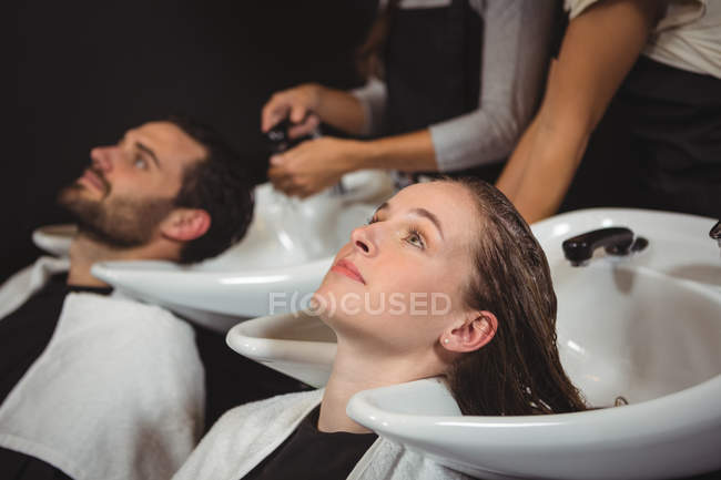 Clientes lavándose el pelo en el salón - foto de stock