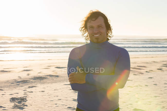 Серфер улыбается в камеру на пляже — стоковое фото