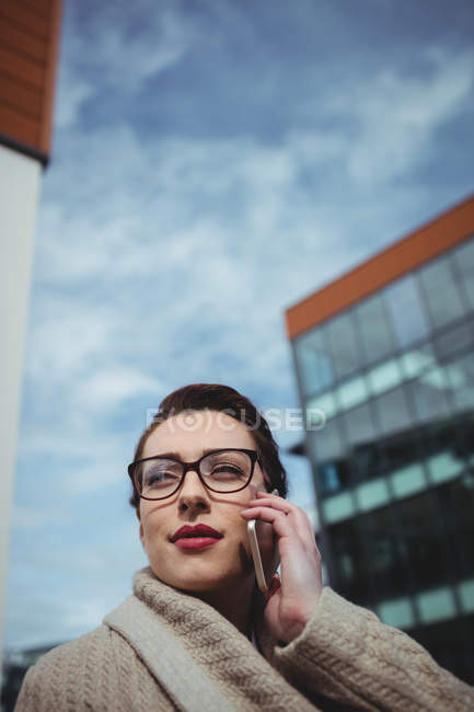 Young woman talking on phone against sky — Stock Photo