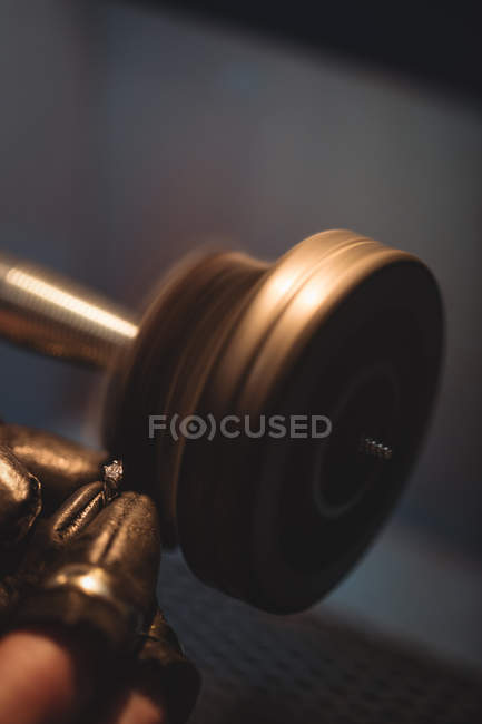 Cropped image of goldsmith polishing ring in workshop — Stock Photo