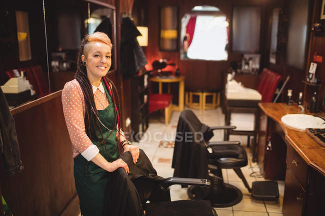 Portrait of smiling female barber standing in barber shop — Stock Photo