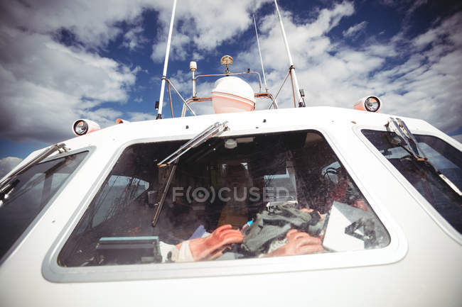 Рыбак за рулем рыболовного судна в солнечный день — стоковое фото
