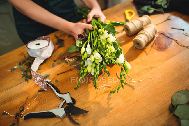 Image recadrée d'une fleuriste préparant un bouquet de fleurs dans sa boutique de fleurs — Photo de stock
