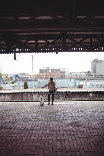 Вид сзади женщины, ждущей на платформе железнодорожного вокзала — стоковое фото