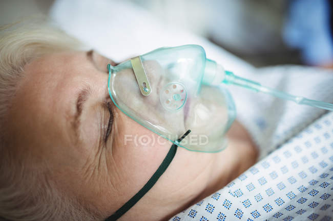 Senior patient with oxygen mask in hospital — Stock Photo