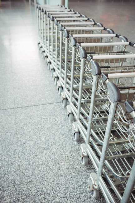 Trolleys im Flughafenterminal hintereinander abgestellt — Stockfoto