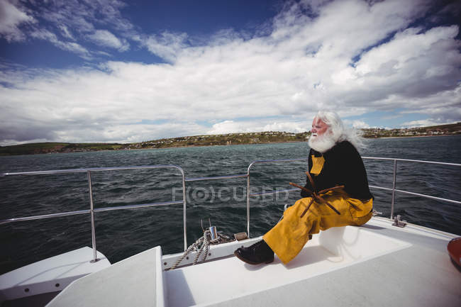 Nachdenklicher Fischer sitzt auf Fischerboot — Stockfoto