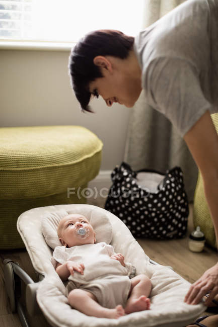 Mãe olhando para seu bebê no carrinho em casa — Fotografia de Stock
