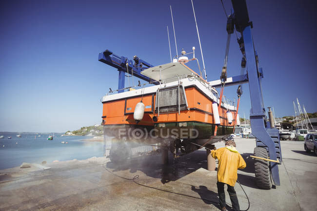 Homme bateau de nettoyage avec lave-pression le jour ensoleillé — Photo de stock