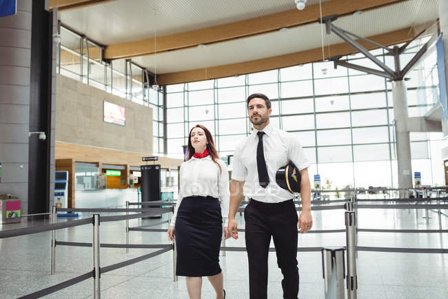 Pilota e assistente di volo a piedi in aeroporto — Foto stock