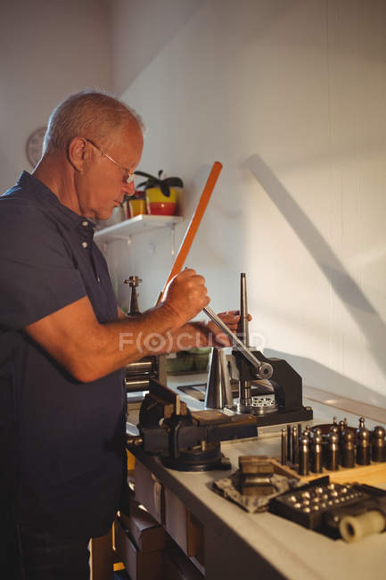 Focused goldsmith using mini drill press in workshop — Stock Photo