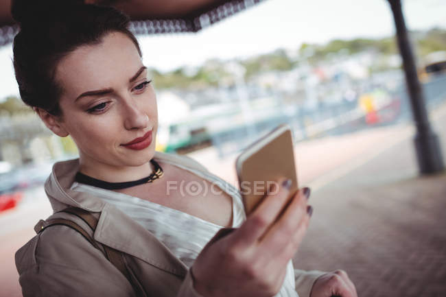 Mulher bonita usando telefone celular na plataforma estação ferroviária — Fotografia de Stock