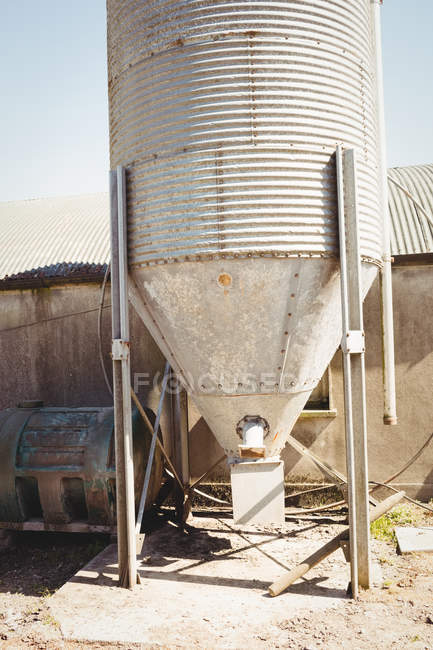 Antiguo tanque de almacenamiento junto al edificio del granero - foto de stock