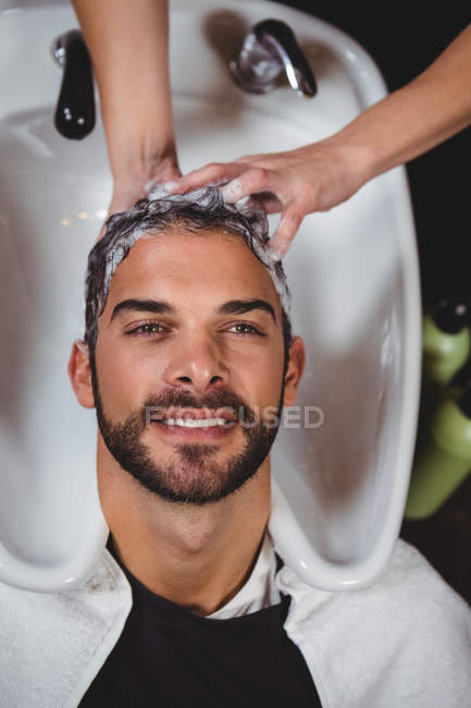 Мужчина моет волосы в салоне — стоковое фото