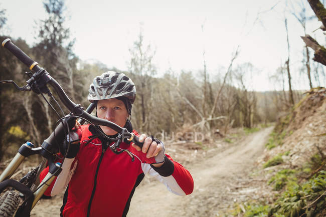 Vorderansicht eines Mountainbikers mit Fahrrad auf Feldweg — Stockfoto