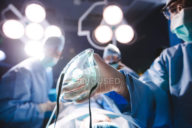 Хирург держит кислородную маску в операционной в больнице — стоковое фото