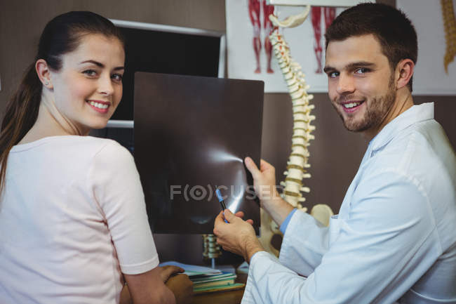 Männlicher Therapeut zeigt Patientin in Klinik Röntgenbild — Stockfoto