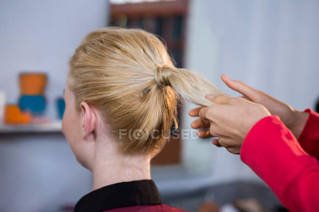 Female hairdresser styling customers hair at a salon — Stock Photo