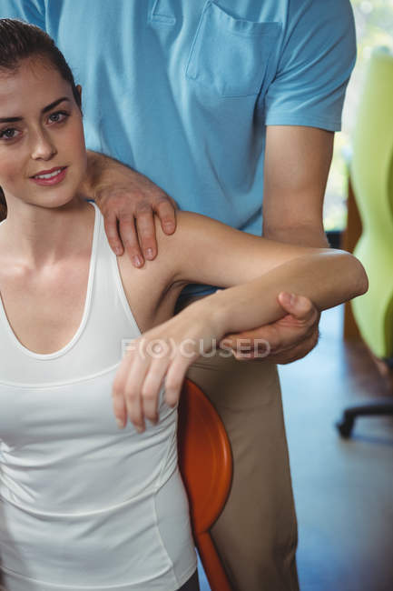 Ritratto del fisioterapista braccio teso della paziente in clinica — Foto stock