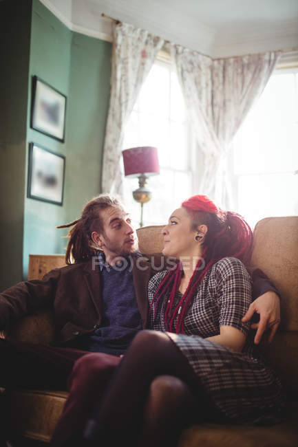 Romântico casal hipster sentado no sofá em casa — Fotografia de Stock