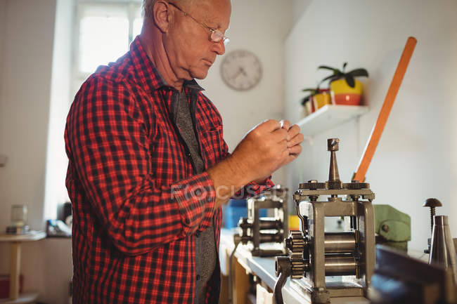 Goldsmith manufacturing ring in workshop — Stock Photo
