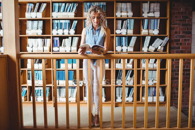 Красивая женщина читает книги в библиотеке — стоковое фото