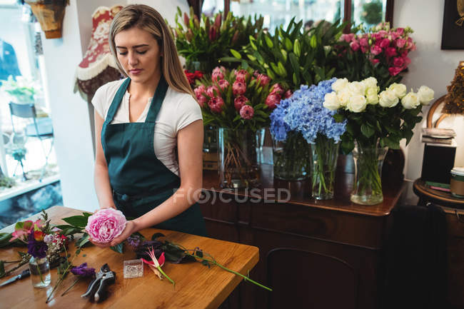 Florista feminina preparando buquê de flores em sua loja de flores — Fotografia de Stock