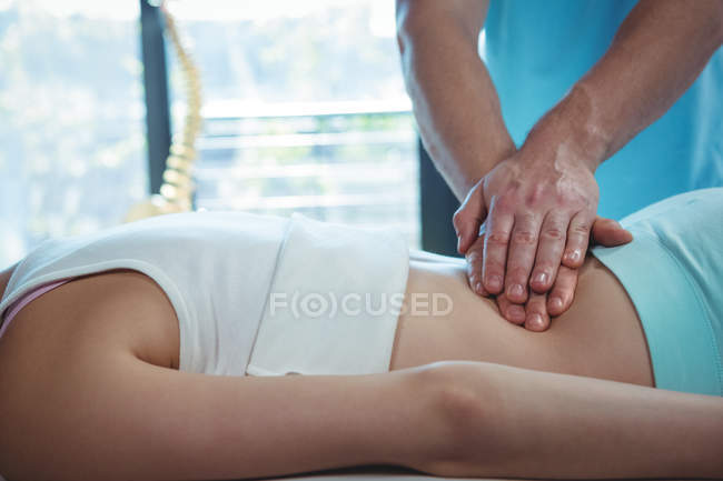Imagem recortada de fisioterapeuta masculino dando de volta massagem para paciente do sexo feminino na clínica — Fotografia de Stock