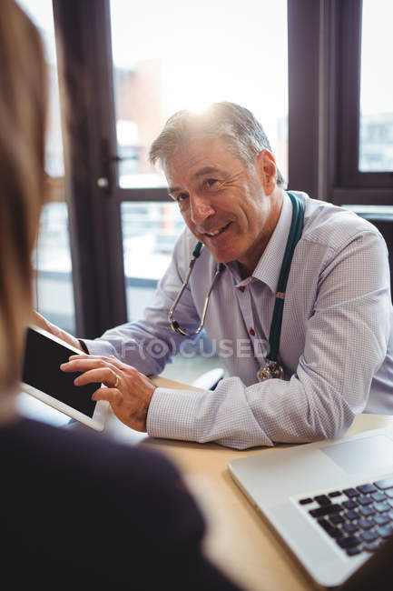 Доктор обговорює з пацієнтом цифровий планшет у лікарні — стокове фото