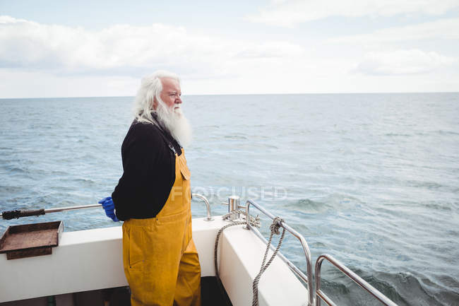 Вдумливий рибалка дивиться з рибальського човна — стокове фото