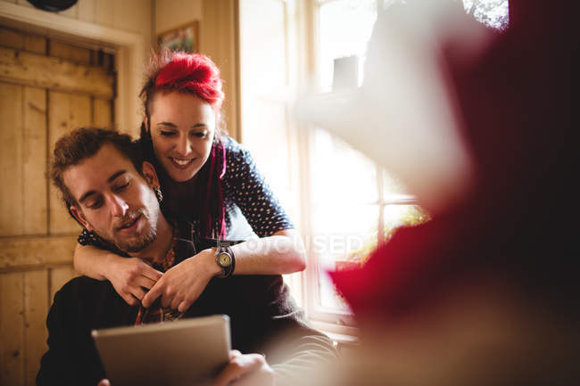 Sorrindo casal hipster usando tablet digital em casa — Fotografia de Stock