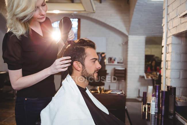 Man getting his hair dried with hair dryer in salon — Stock Photo