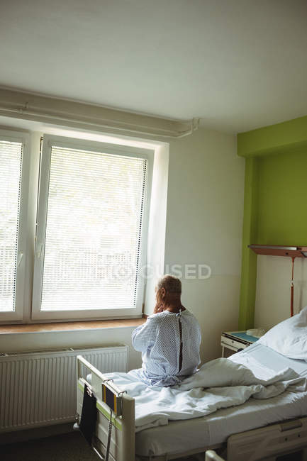 Старший чоловік сидить на ліжку в лікарні — стокове фото