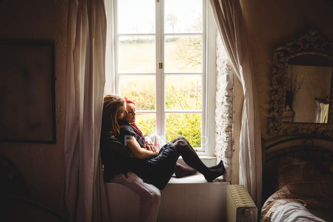Junges Hipster-Paar umarmt sich zu Hause gegen Fenster — Stockfoto