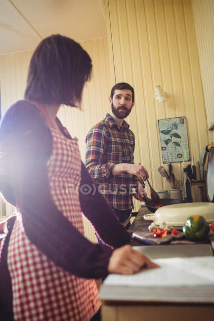 Woman reading a recipe book in kitchen at home — Stock Photo