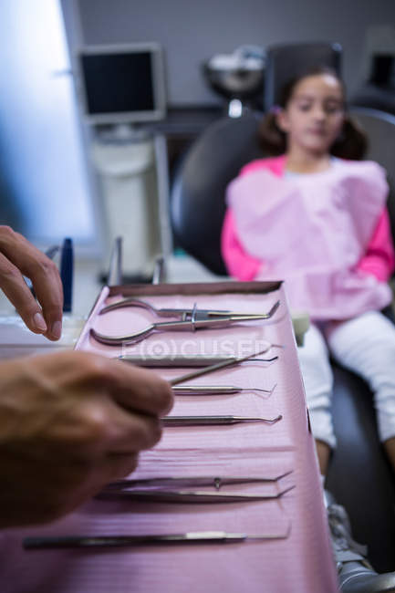 Zahnarzt holt Zahnwerkzeug zur Untersuchung junger Patientin in Klinik — Stockfoto
