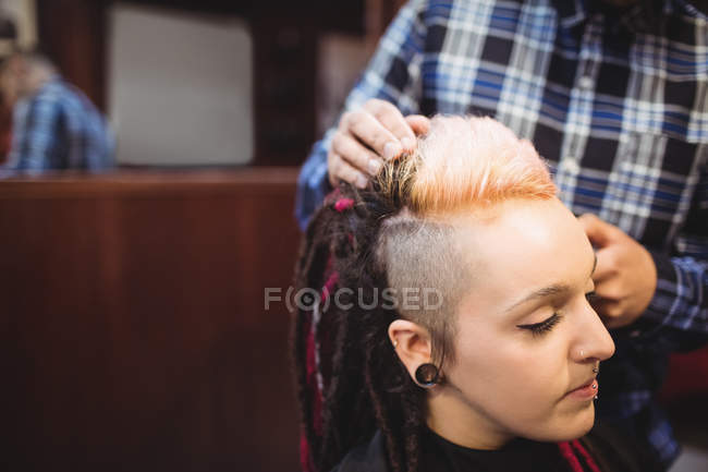 Mulher recebendo seu cabelo aparado com aparador na barbearia — Fotografia de Stock