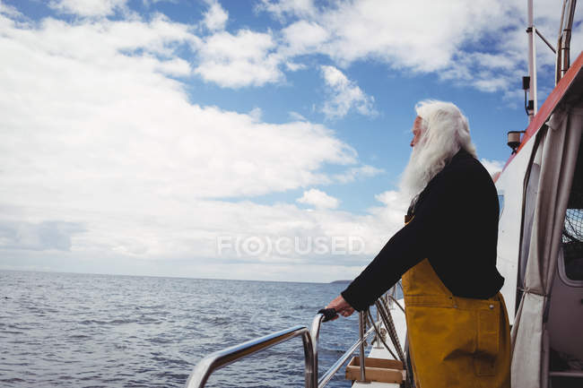 Pescador olhando para o mar de barco de pesca — Fotografia de Stock