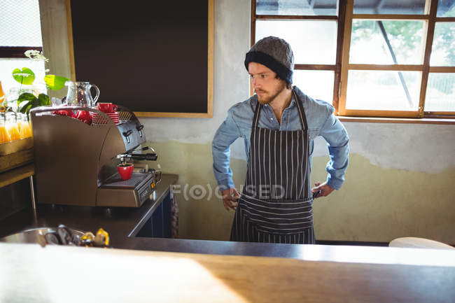 Waiter tying his apron in cafe at bicycle shop — Stock Photo