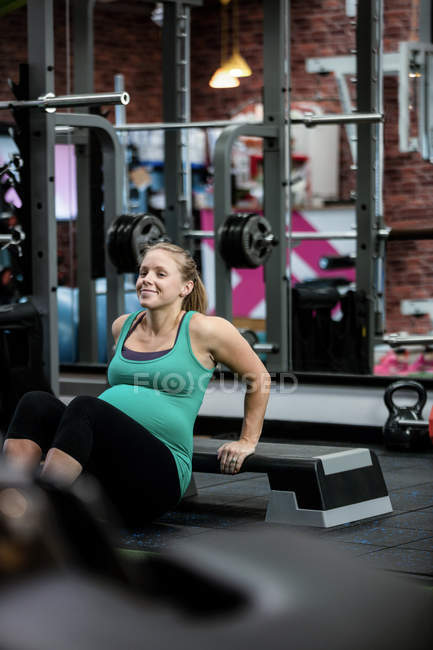 Donna incinta che esegue esercizio di stretching in palestra — Foto stock
